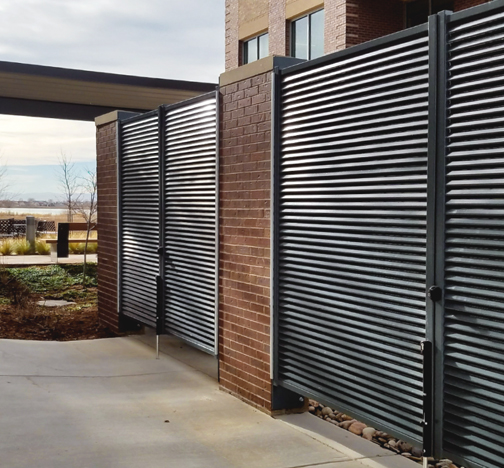 Omega 100 louvered gates in front of a garbage disposal located outside of a condo building.