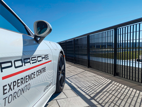 A Porsche parked in front of an Omega 10 fence guardrail on the observation deck at PEC Toronto.